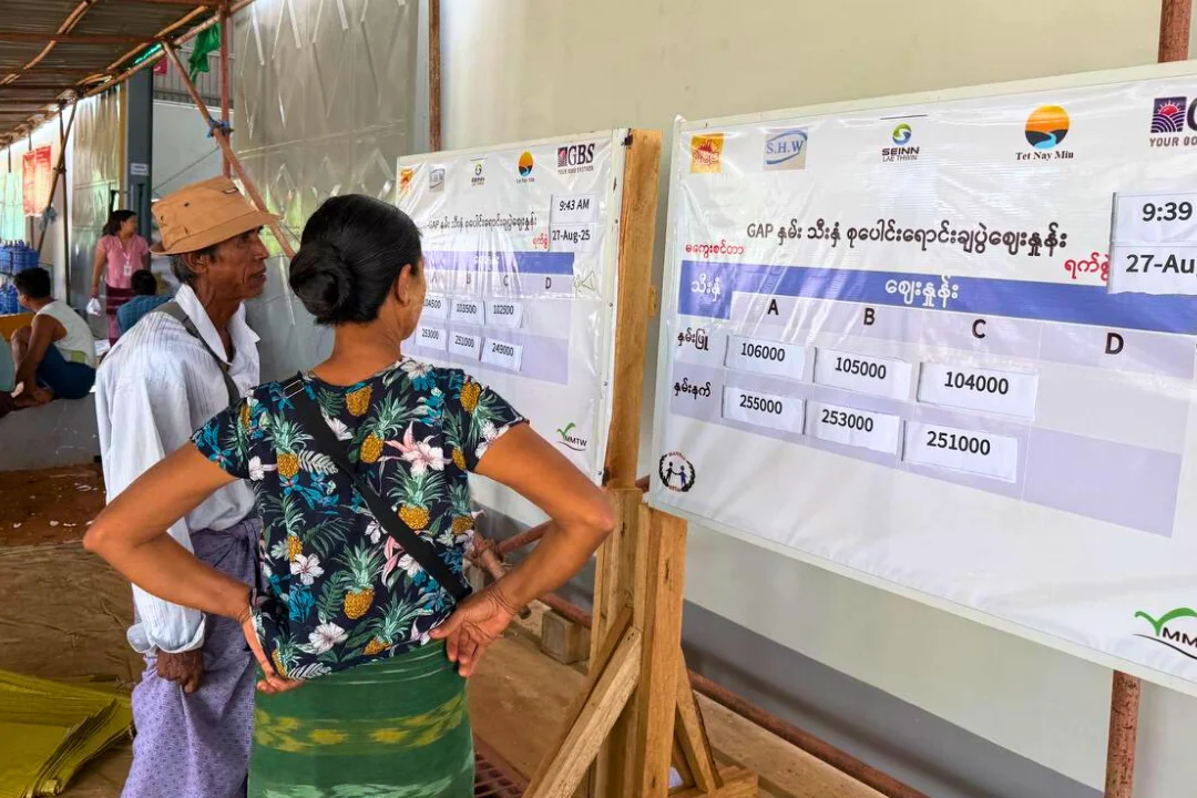 Farmers viewing price board at collective selling event