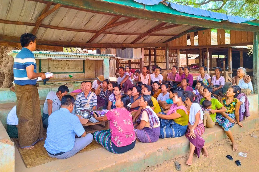 Outdoor farmer gathering under village shelter